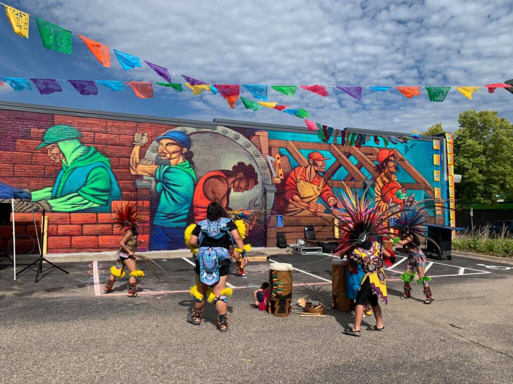 A group of performers move in a circle around a pair of drums.