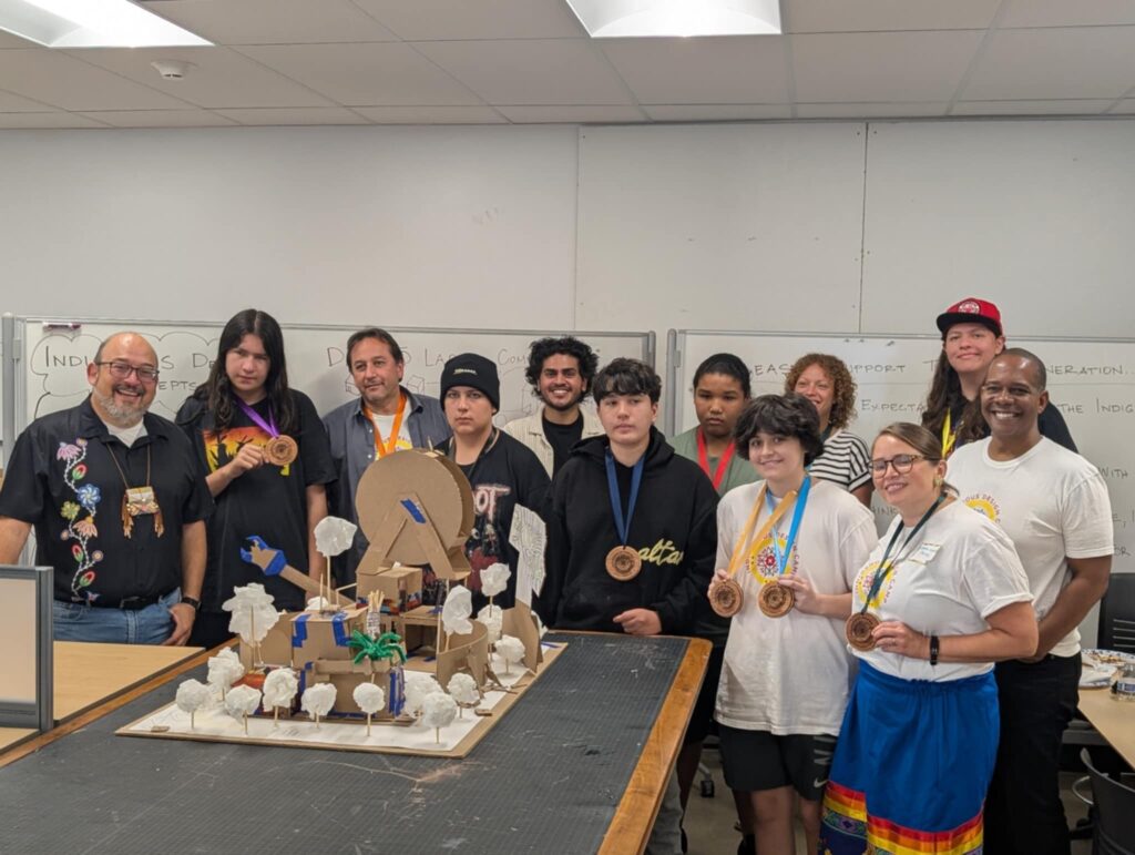 A group of young people and adults standing together in a classroom.