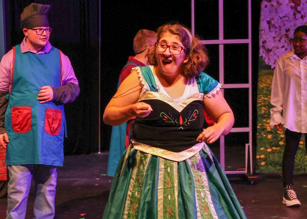 People perform on stage wearing costumes.