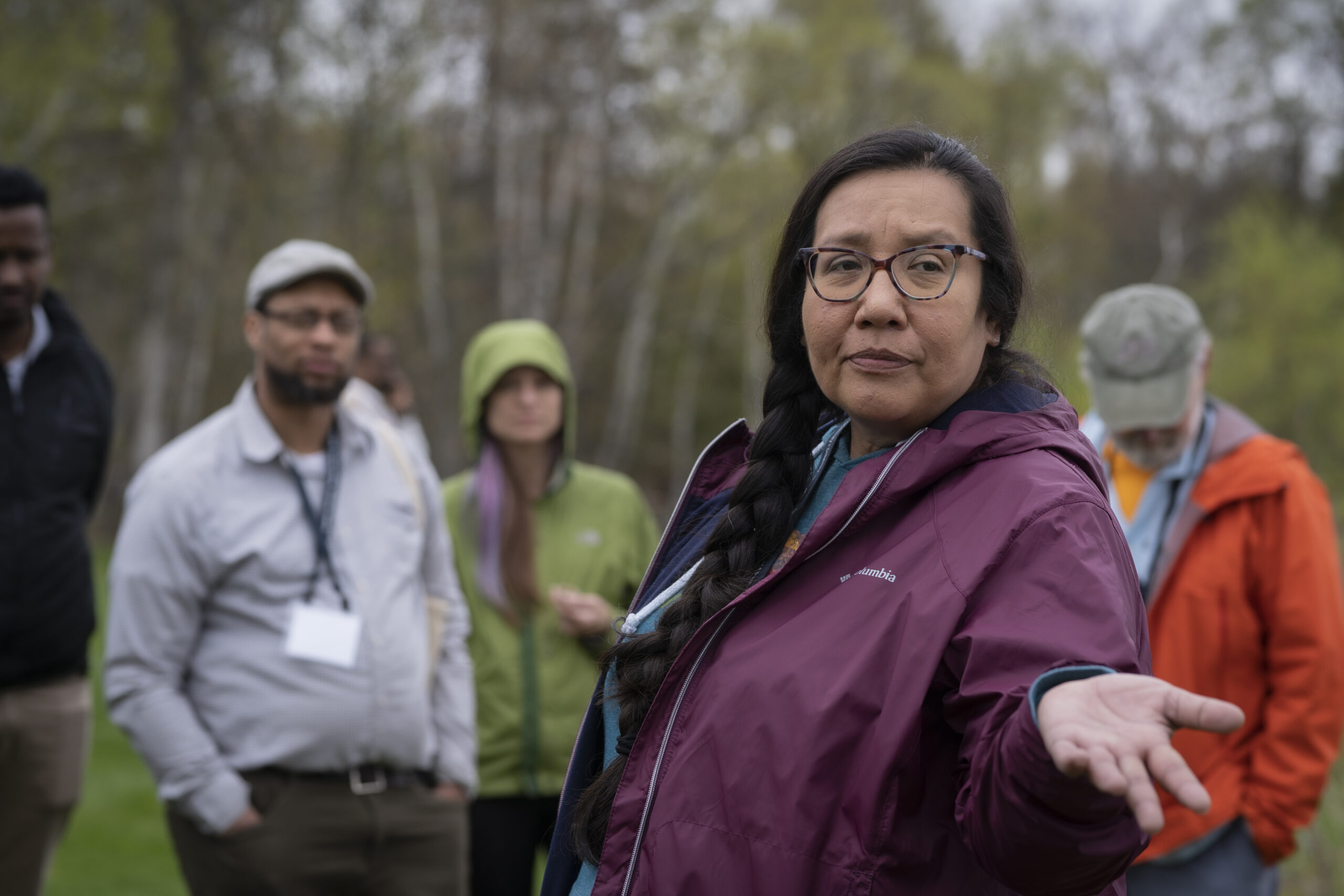 Jennifer Martel from Sitting Bull College stands in front of members of the CCC2 cohort outside, sharing her work around herbal resilience and community wellness at the May 2022 CCC2 Retreat.