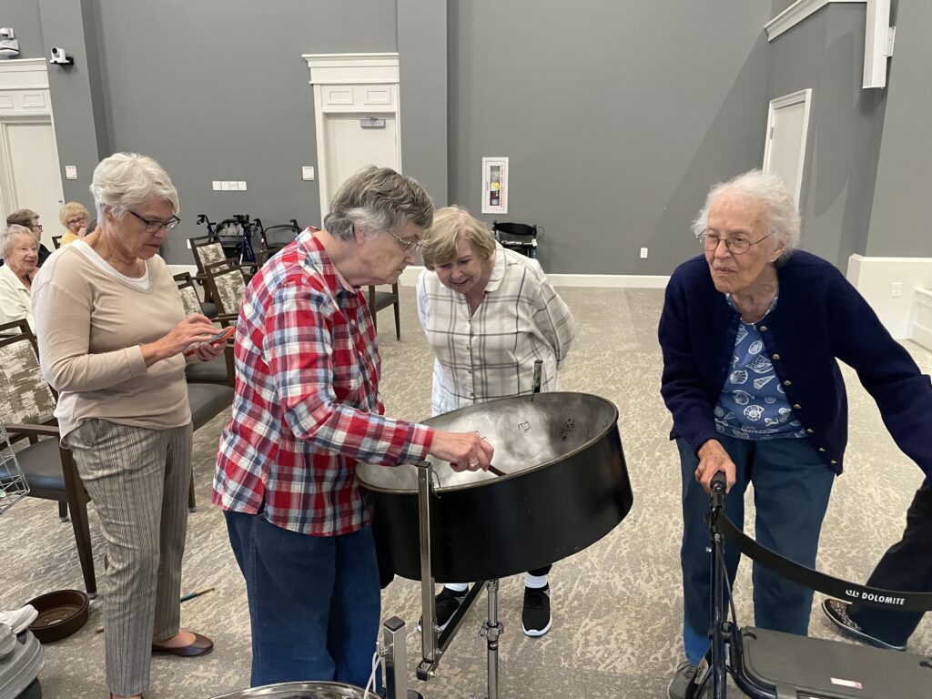 Four older women around a steel drum.