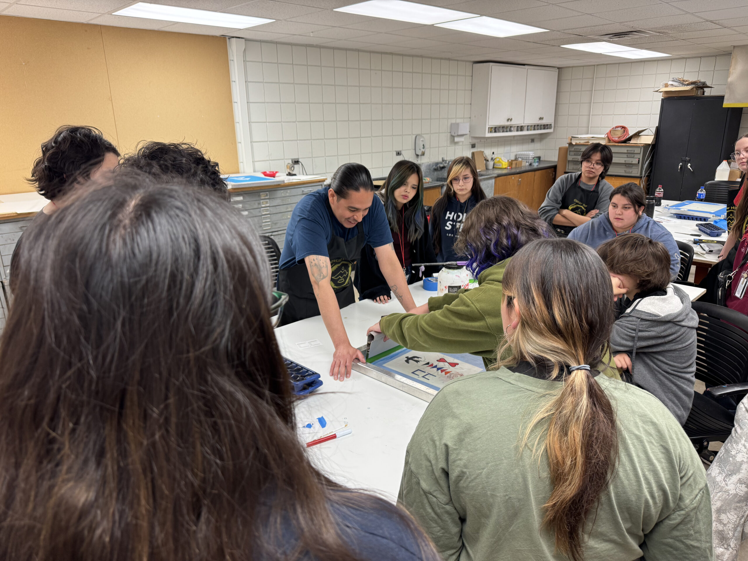 Peeople gather around a table.